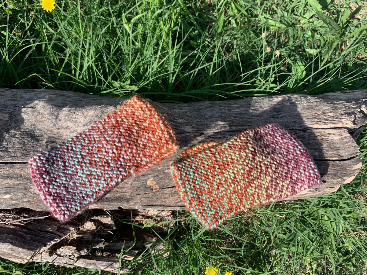Femme portant un bandeau tricoté main au point mousse tons chauds rose et orange avec nœud twist, accessoire hivernal artisanal MALOU au Fil des Saisons
